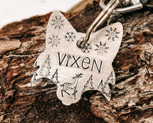 Load image into Gallery viewer, Christmas fox head dog id tag, hand stamped with cute reindeer, snowflakes and trees