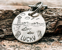 Load image into Gallery viewer, Ocean dog tag, hand stamped with sharks and lighthouse