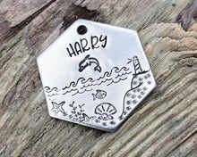 Load image into Gallery viewer, Hexagon dog tag, hand stamped with nautical design, dolphin & lighthouse
