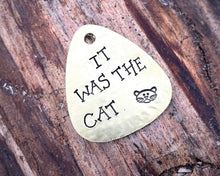 Load image into Gallery viewer, Guitar pick dog tag, hand stamped with 'it was the cat'
