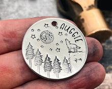 Load image into Gallery viewer, Large dog tag, hand stamped with howling wolf, trees, moon & stars