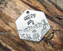 Load image into Gallery viewer, Hexagon dog tag, hand stamped with nautical design, dolphin & lighthouse