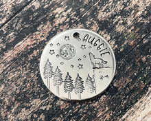 Load image into Gallery viewer, Large dog tag, hand stamped with howling wolf, trees, moon & stars