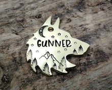 Load image into Gallery viewer, Wolf head dog tag, hand stamped with adventure design, mountains & trees