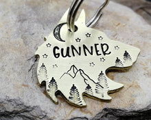 Load image into Gallery viewer, Wolf head dog tag, hand stamped with adventure design, mountains & trees