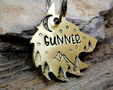 Load image into Gallery viewer, Wolf head dog tag, hand stamped with adventure design, mountains & trees