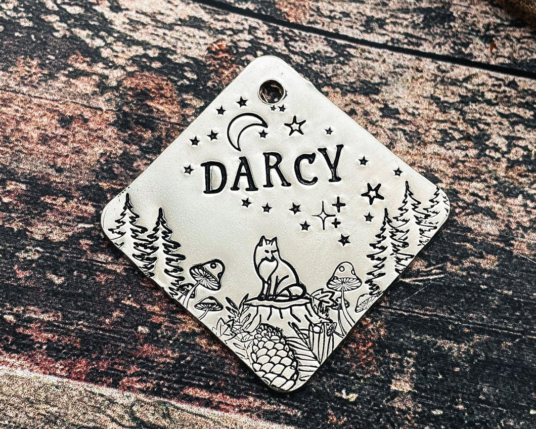 square metal dog id tag with fox and trees