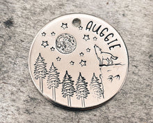 Load image into Gallery viewer, Large dog tag, hand stamped with howling wolf, trees, moon &amp; stars
