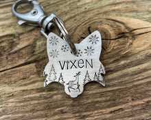 Load image into Gallery viewer, Christmas fox head dog id tag, hand stamped with cute reindeer, snowflakes and trees
