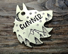 Load image into Gallery viewer, Wolf head dog tag, hand stamped with adventure design, mountains &amp; trees
