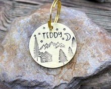 Load image into Gallery viewer, Dog id tag, hand stamped with mountains, trees &amp; cabin
