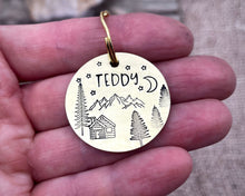Load image into Gallery viewer, Dog id tag, hand stamped with mountains, trees &amp; cabin
