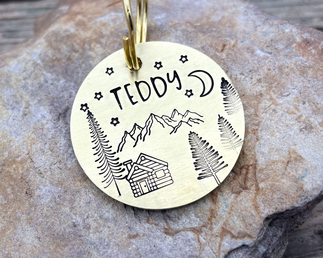 Dog id tag, hand stamped with mountains, trees & cabin